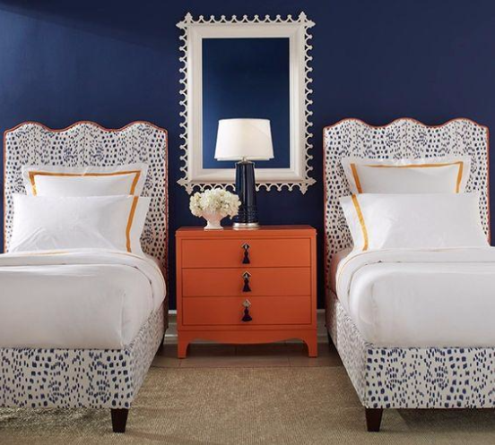 White and blue twin beds with orange table